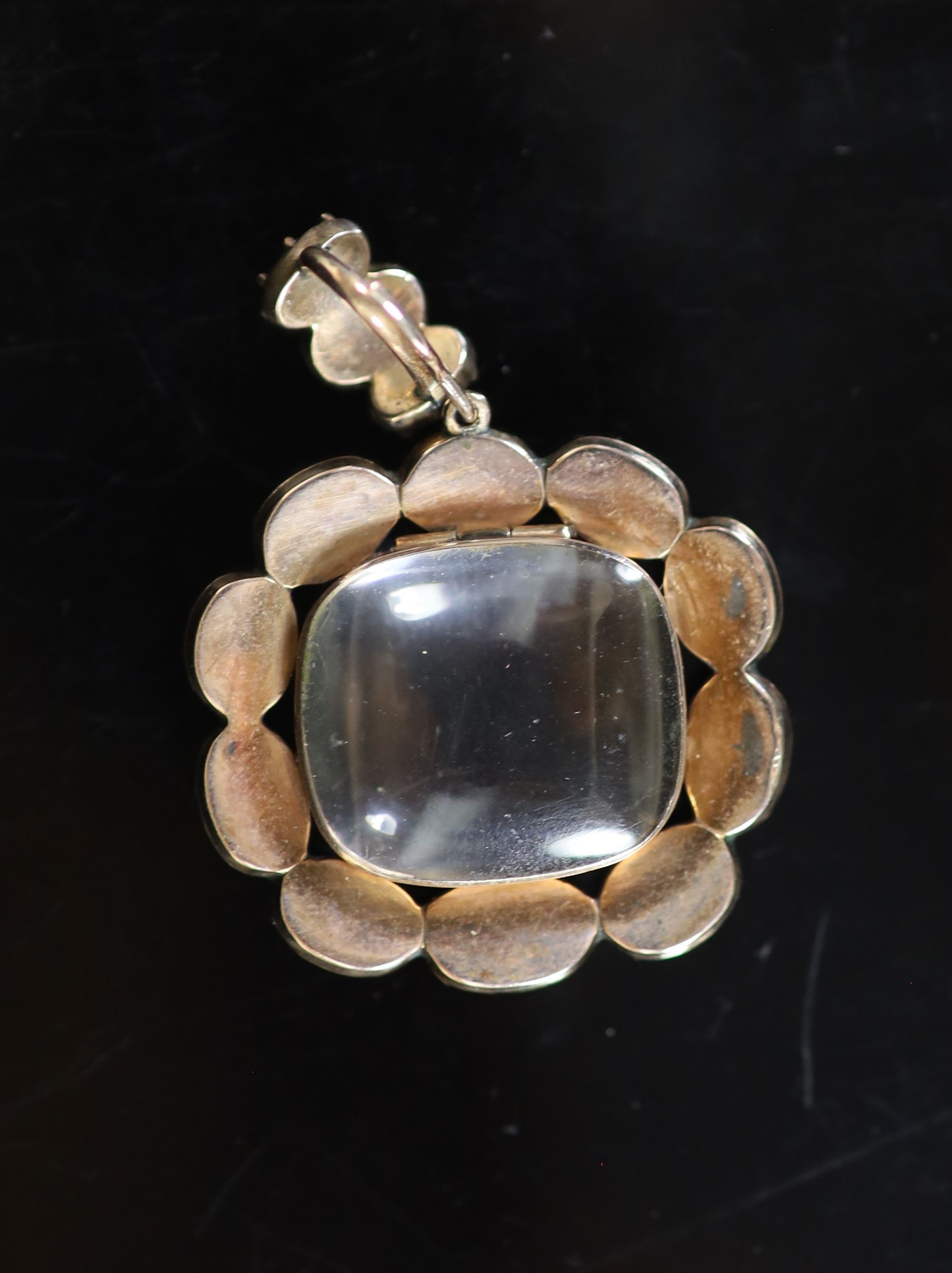 A Victorian gold, rock crystal and thirteen stone foil backed oval cut garnet set pendant